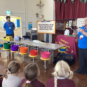 Dau berson yn rhoi cyflwyniad PowerPoint i'r plant.