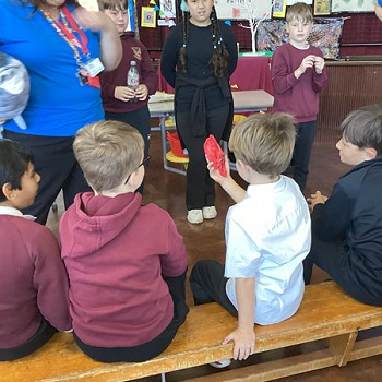 Myfyriwr yn dal rhywbeth coch.
