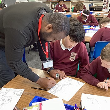 Artist Mfikela Jean Samuel helping a pupil in class