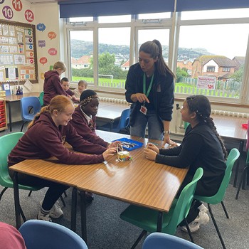 students talking with a teacher around a table