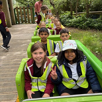 group of children sitting on a rollercoster